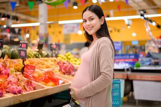 Beautiful pregnant woman shopping healthy food at grocery shop photo
