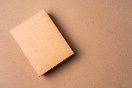 Cardboard box on beige background in studio photo