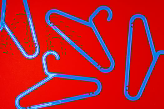 Hanger on red paper background. Minimalistic fashion concept. Top view photo