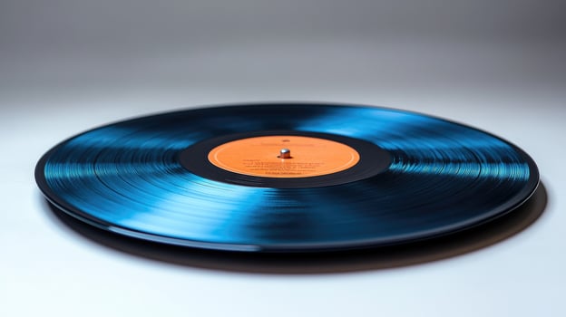 Shiny blue vinyl record spinning on turntable with orange label photo
