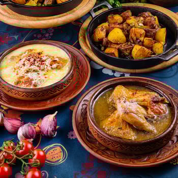 Traditional georgian food served in clay pots standing on a decorated table photo