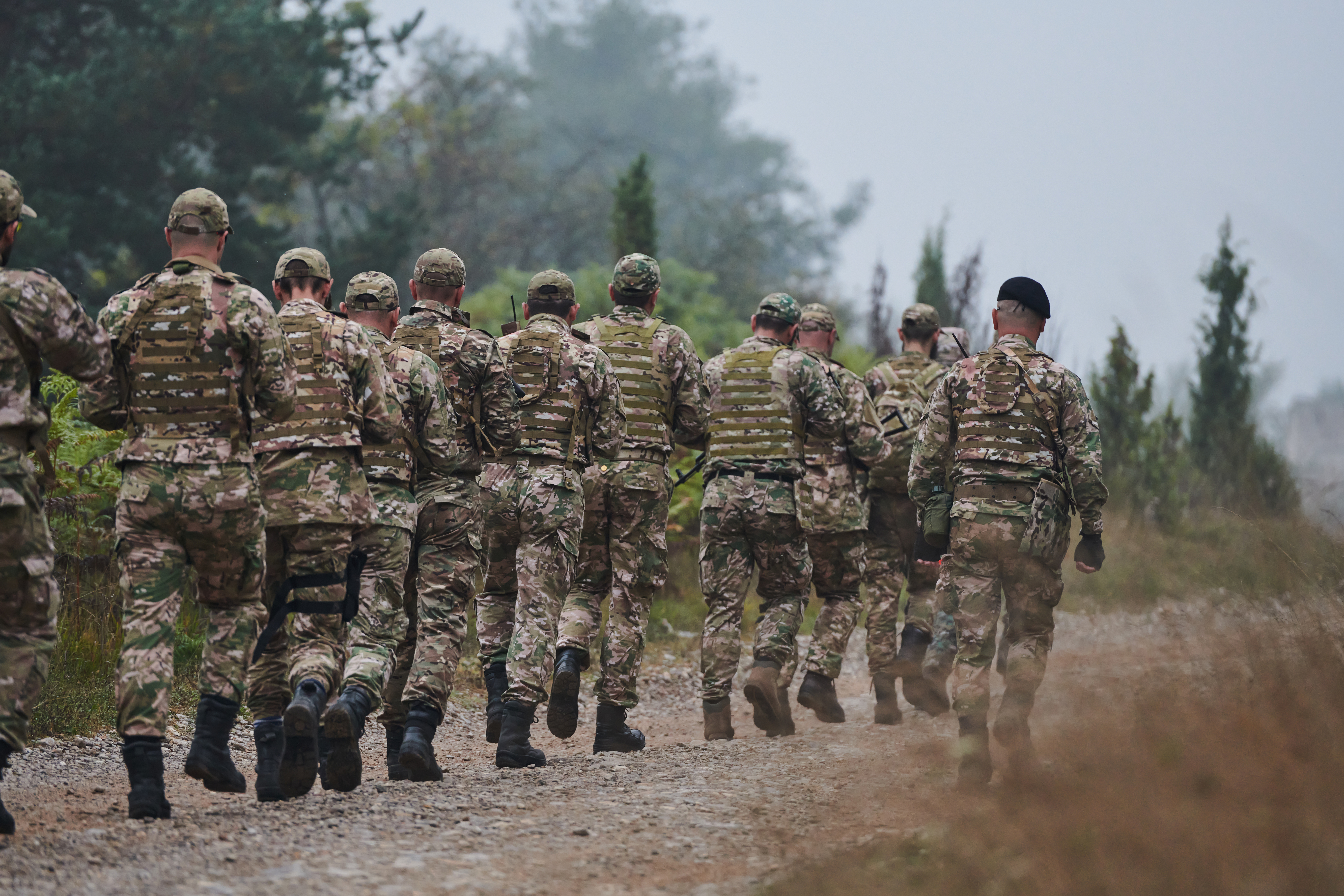 An elite military unit, led by a major, confidently parades through dense forest, showcasing precision, discipline, and readiness for high-risk operations photo
