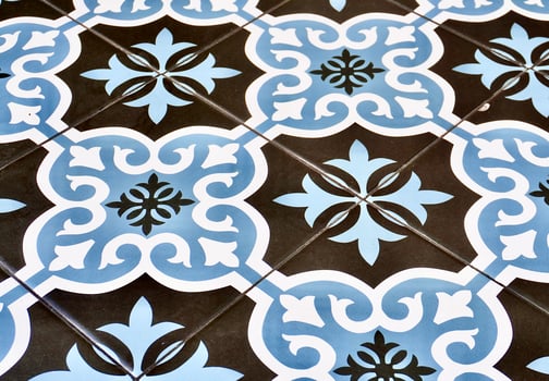 Blue, white, and dark gray ceramic floor tile with decorative pattern texture isolated on horizontal ratio background. photo