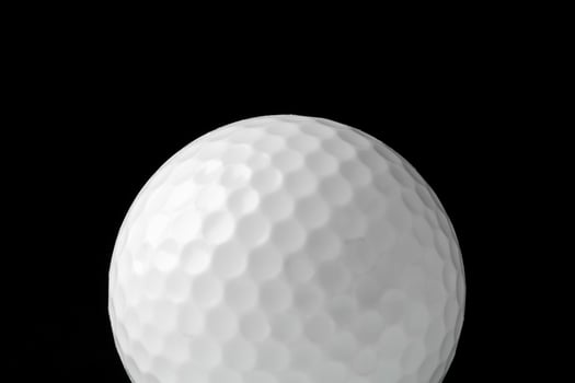 Golf ball close up on black background photo