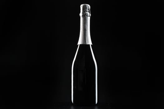 Champagne bottle on dark black background close up photo