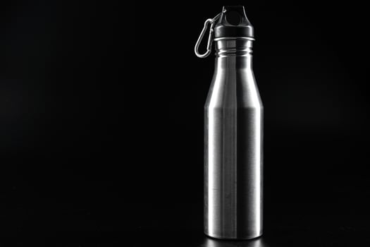 Sport bottle for drink on black background photo