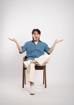 Portrait of young Asian business man sitting in chair, isolated on white background photo