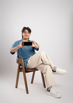 Portrait of young Asian business man sitting in chair, isolated on white background photo