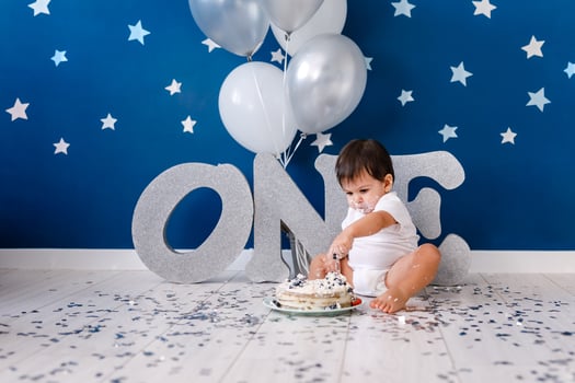 curious baby boy poking finger in his first birthday cake photo