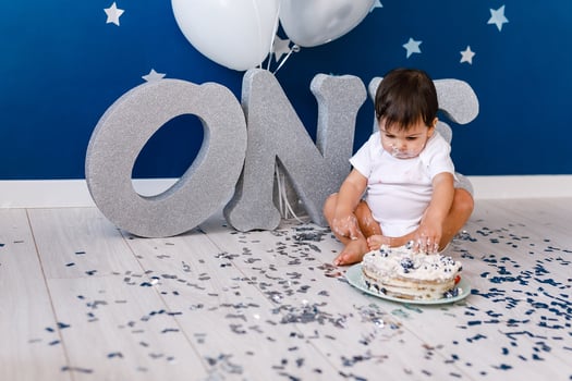 curious baby boy poking finger in his first birthday cake photo
