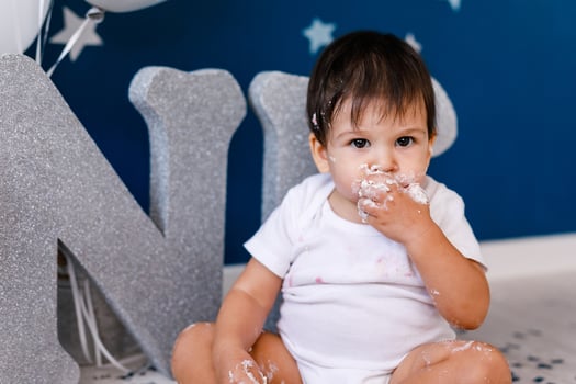 curious baby boy poking finger in his first birthday cake photo