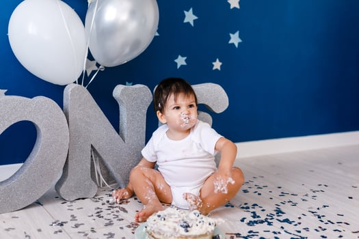 curious baby boy poking finger in his first birthday cake photo