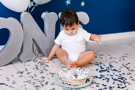 curious baby boy poking finger in his first birthday cake photo