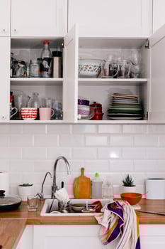 Clutter, dirty dishes by the sink in the white kitchen photo
