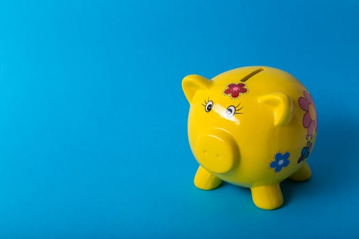 Yellow piggy bank on blue background photo