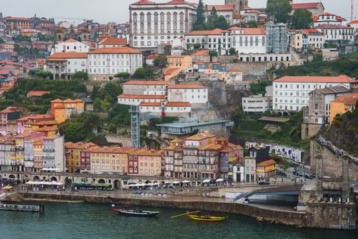 Colorful historic buildings, a funicular railway, and a bustling waterfront along the Douro River in Porto, Portugal. Vibrant architecture and lively promenade. photo