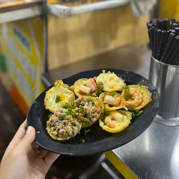 Savor the crispy perfection of Banh Khot, golden mini pancakes topped with fresh ingredients and bursting with vibrant flavors photo