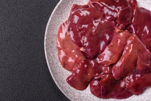 Fresh raw chicken or beef liver with salt, spices and herbs photo