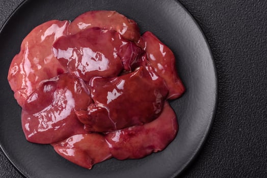 Fresh raw chicken or beef liver with salt, spices and herbs photo