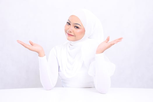 closeup portrait of young female asia skin care smiling down both hands presenting with bright, glowing and smooth skin tone. studio on white background isolated for advertising concept. beauty photo
