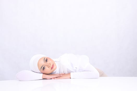 portrait charm Young woman hijab beautiful head sleeping look at camera hands relax on white table isolated white background. concept cosmetics, health, skin care banner, treatment photo
