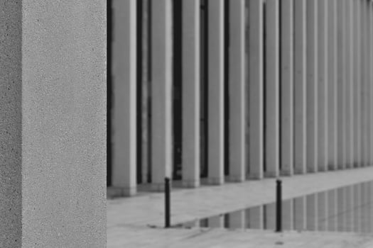 gray pillar with a black pole leaning on it photo