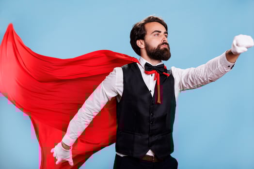 Strong character with fantasy cape standing in studio with blue background, acting confident and determined on camera. Powerful person presenting dedication to protect citizens. photo
