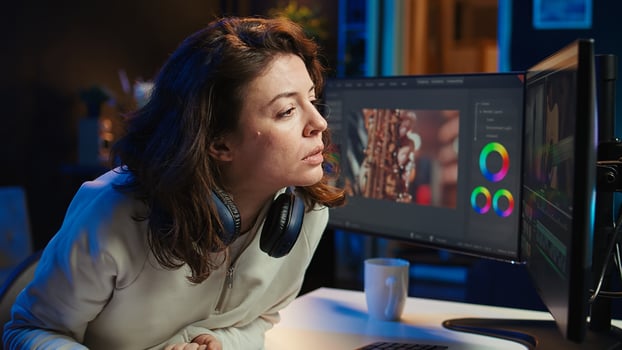 Happy videographer using professional software to create visual effects for projects, proud of results. Smiling expert using post production techniques to edit raw clips footage, camera B photo