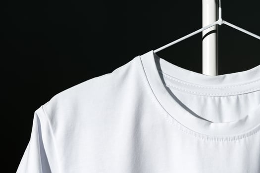 Blank T-shirt hanging in a spotlight in studio photo