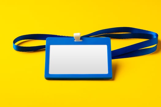 Blank nametag on a string on yellow background copy space photo