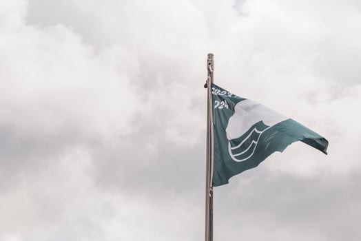 Blue flag with cloudy windy sky at certificated beach in Mexico. photo