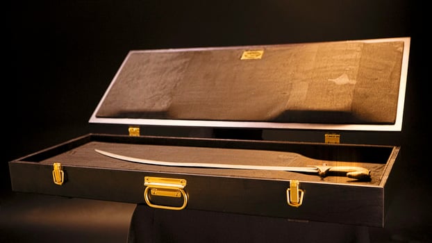 Exhibit in museum is old saber on isolated background. Stock footage. Old saber is in open suitcase as exhibit in museum of weapons or folk life photo
