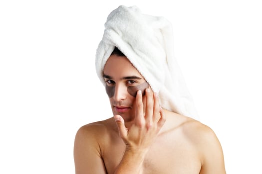 Portrait of attractive young male model with eye patches on white background photo