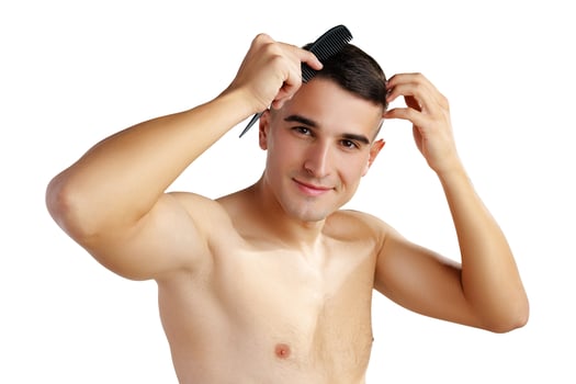Portrait of handsome young man combing his hair on white background photo
