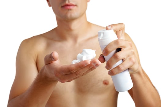 Unrecognizable man holding shaving foam in hands against white background photo