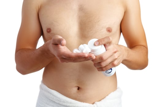 Unrecognizable man holding shaving foam in hands against white background photo