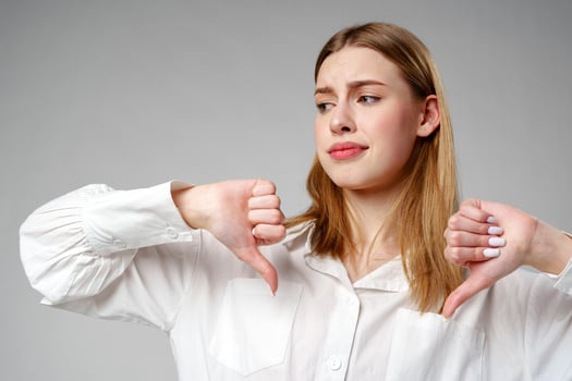 Young Woman in White Shirt Pointing Finger Down Dislike photo