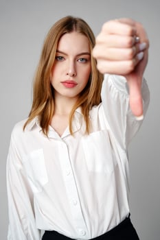 Young Woman in White Shirt Pointing Finger Down Dislike photo
