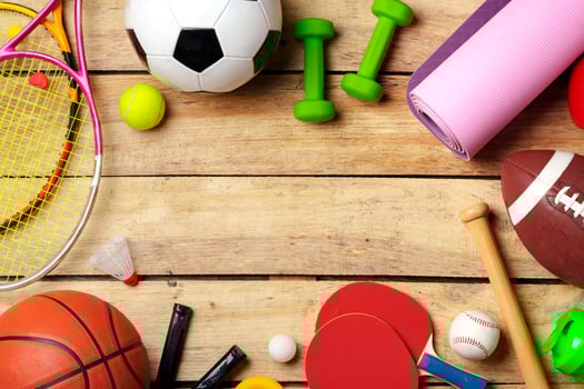 Different sports equipment on wooden background top view photo