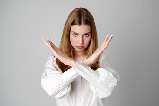 Young Woman Making X Sign With Arms to Express Prohibition or Disagreement photo