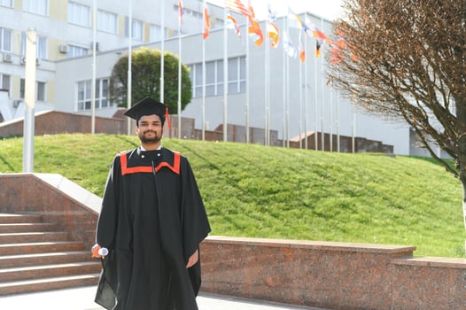 Handsome indian graduate in graduation glow with diploma photo