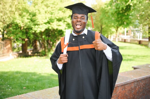 smiling african american graduated student showing diploma photo