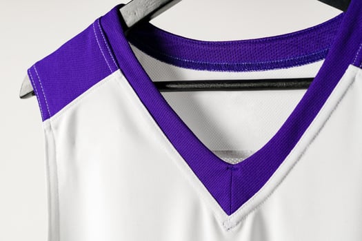White basketball jersey hanging against white background photo