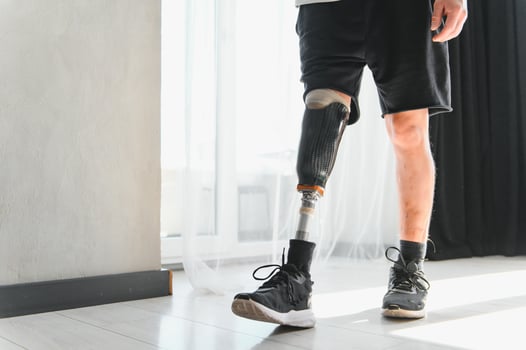 Unrecognizable man with bionic prosthetic leg at home indoors, copy space photo