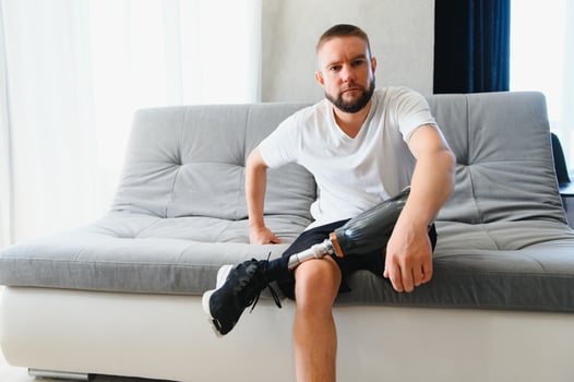 Portrait of man with prosthetic leg at home, copy space photo