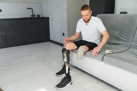 Portrait of a young man with a prosthetic leg at home photo