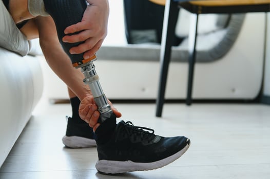 Closeup of unrecognizable man with bionic prosthetic leg at home indoors, copy space photo