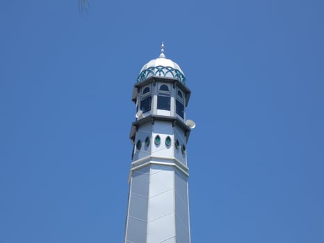 Muslim mosque. Mosque minaret with copper-covered dome against azure sky. emblematic of Ramadan and Islam. photo