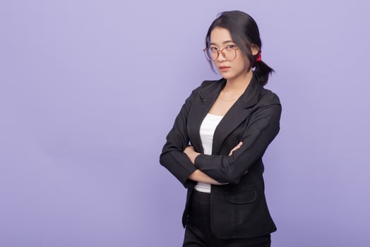 Portrait of a young asian business woman standing against purple background photo