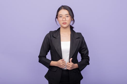 Young asian business woman in suit against purple background photo